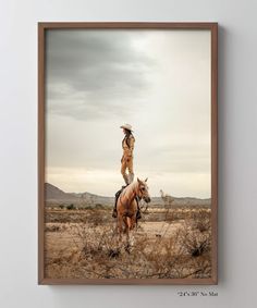 a man riding on the back of a brown horse next to a dry grass field