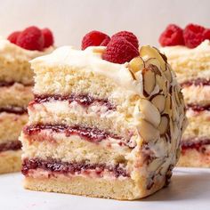 two pieces of cake with raspberries and almonds on top