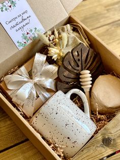 an open box containing coffee, soaps and other items on a wooden table top