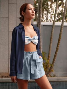 Stay cool and stylish this spring in our 100% silk Charlotte shorts. Featuring a comfy, adjustable waistband and a playful ruffle trim, these pull-on shorts offer effortless elegance. Soft elastic and darling patch pockets add a touch of sophistication, while the subtle sheen lets them transition from poolside lounging (pair with a bikini!) to breezy nights (think cozy sweater and sandals). The perfect versatile piece for brunches, picnics, garden parties, and beyond! 100% Washed Silk Taffeta Measurements: Inseam 2.25”, Inseam to Waist 12.5” Summer Ruffle Pajama Shorts, Chic Pajama Shorts, Summer Ruffled Pajama Shorts, Ruffled Pajama Shorts For Summer, Blue Shorts For Spring Daywear, Blue High-waisted Shorts For Day, Blue Shorts For Summer Daywear, Summer Daywear Shorts With Ruffles, Casual Ruffled Shorts For Daywear