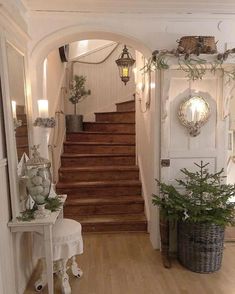 an entry way with stairs and potted plants