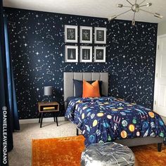 a bedroom decorated in blue and orange with pictures on the wall