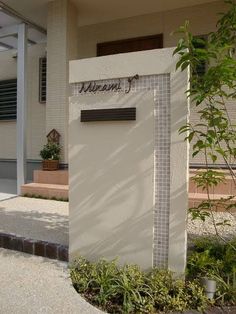 there is a sign that says welcome to the front of a building with trees and bushes around it