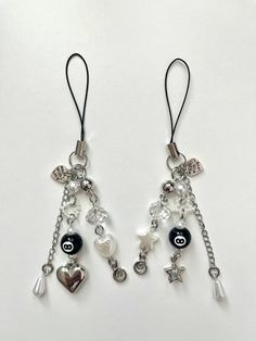 two pairs of earrings with charms hanging from them