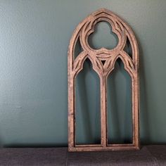 a wooden window frame sitting on top of a shelf next to a green painted wall