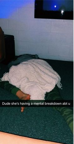 a person laying on the floor with a blanket