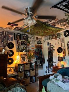 the ceiling fan is hanging from the ceiling in this room with many pictures on it