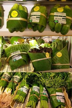 vegetables are displayed in baskets on shelves at a grocery store with price tags attached to them