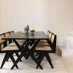 a dining table with chairs and a vase on it