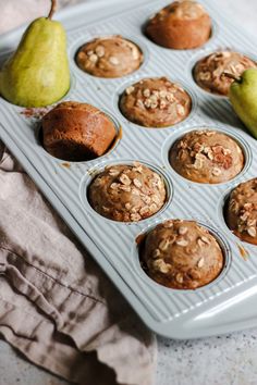 muffins in a muffin tin with pears and walnuts on top