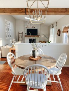 a dining room table with white chairs around it