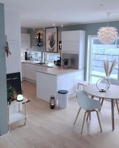 an open concept kitchen and dining room with white furniture