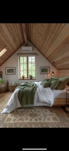 a bed sitting under a window in a bedroom next to a wooden floor and ceiling