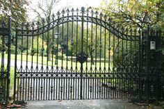 an iron gate in the middle of a park