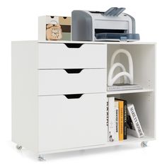 a white cabinet with three drawers and a printer on it's top shelf next to books