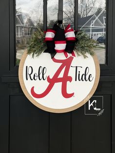 a door hanger that says rolle a tide and has a wreath on it