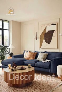 a living room with blue couches and art on the wall behind it, along with a coffee table