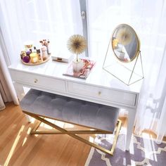 a white desk with a mirror, stool and other items on the table in front of it