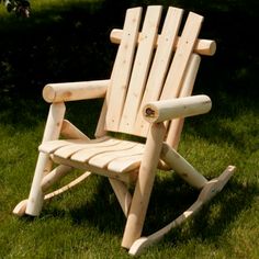 a wooden rocking chair sitting in the grass