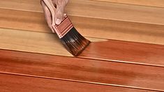 a person using a brush to clean wood floors