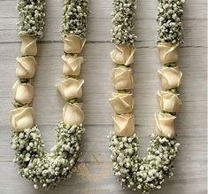 flowers arranged in the shape of the letter u on a wooden surface with white petals and baby's breath