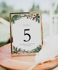 a wooden table with a sign that says five on it and some white feathers next to it