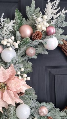 a christmas wreath with poinsettis, pine cones and other decorations on it