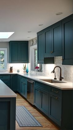 a kitchen with green cabinets and white counter tops