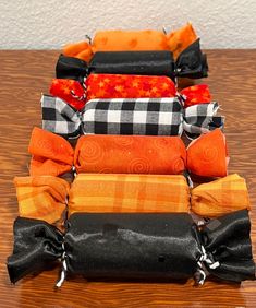 several different types of bags sitting on a wooden table with black and orange ribbons around them