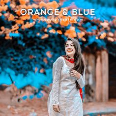 a woman standing in front of an orange and blue tree