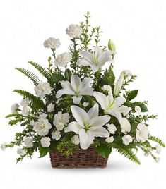 a basket filled with white flowers and greenery