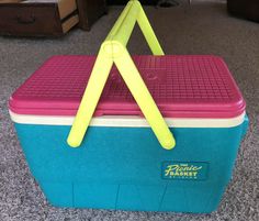 a blue and pink cooler with yellow handles