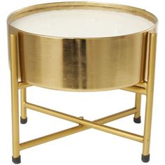 a gold metal tray with a white glass table top sitting on it's legs