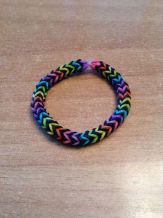 a multicolored bracelet sitting on top of a wooden table