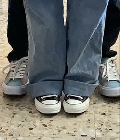 two people standing next to each other with their feet on one another's legs