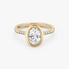 a yellow gold ring with an oval cut diamond in the center