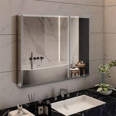 a bathroom with marble counter tops and a large mirror on the wall above the sink