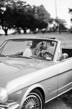 a man and woman are in a convertible car