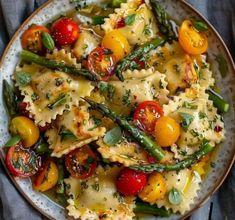 pasta with tomatoes, asparagus and green beans in a white bowl on a blue cloth