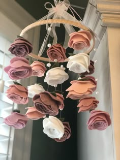 a wind chime with pink and white flowers hanging from it's center piece