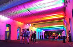 people are standing under a brightly lit covered walkway