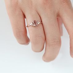 a woman's hand with a pink diamond ring on top of her left hand