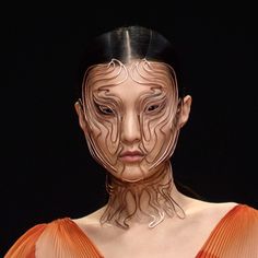 a woman's face is made up of lines and shapes on her body, as if it were part of an art project