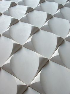 a close up view of the surface of a building with wavy white tiles on it