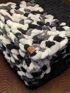 a pile of black and white towels on top of a wooden table