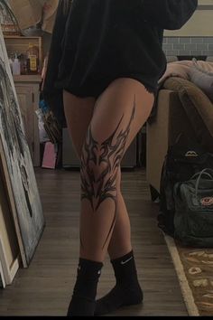 a woman with tattoos on her legs taking a selfie