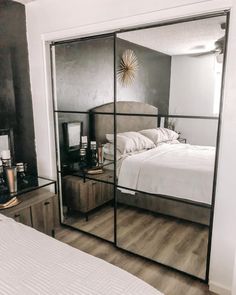 a bedroom with mirrored closet doors and a bed