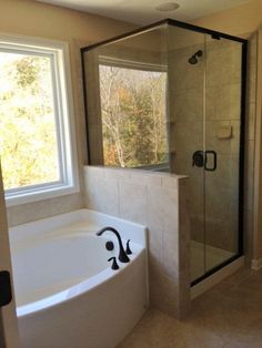 a bath tub sitting next to a window in a bathroom