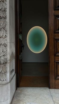 an open door with a circular light hanging from it's side