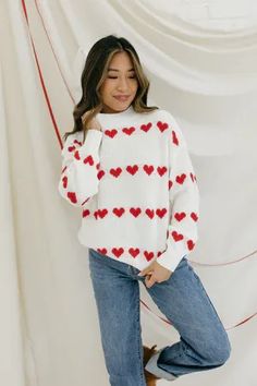 Get ready to fall in love with our Cross My Heart Sweater! This playful top features a relaxed fit and mock neckline, perfect for snuggling up on chilly days. Adorned with striped hearts, it's a cozy and charming addition to your wardrobe.